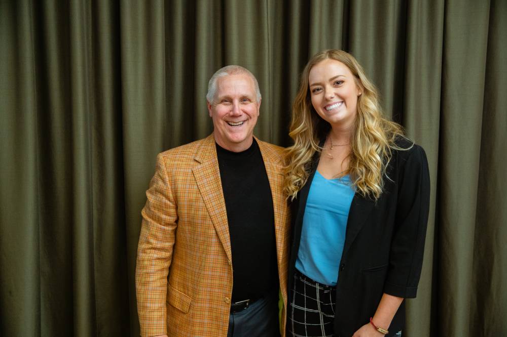 Two guests smiling in front of a backdrop at Scholarship Dinner 2019